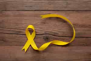 Free photo view of yellow ribbon on wooden background