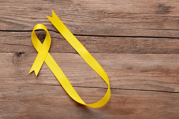 Free photo view of yellow ribbon on wooden background