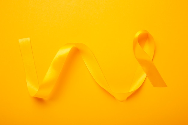 Free photo view of yellow ribbon on yellow background