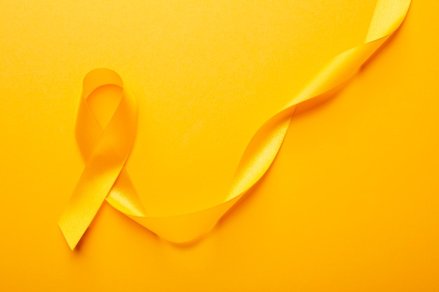 Free photo view of yellow ribbon on yellow background