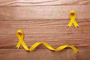 Free photo view of yellow ribbons on wooden background