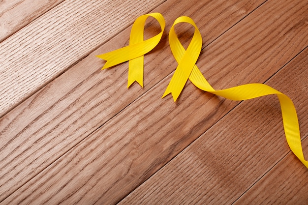 Free photo view of yellow ribbons on wooden background