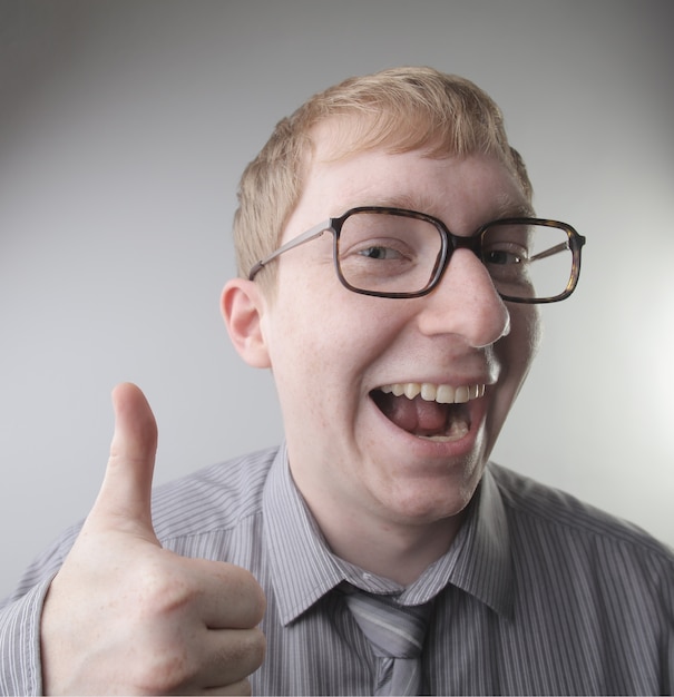 View of a young caucasian male wearing a shirt and tie with happy face impressions - concept: happy