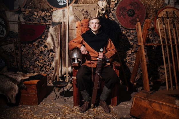 Бесплатное фото Викинг позирует на фоне древнего интерьера викингов.