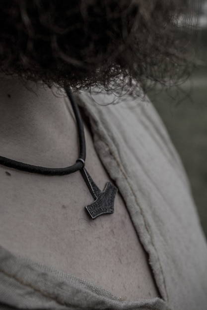 Free photo viking warrior with curly hair wearing a hammer necklace