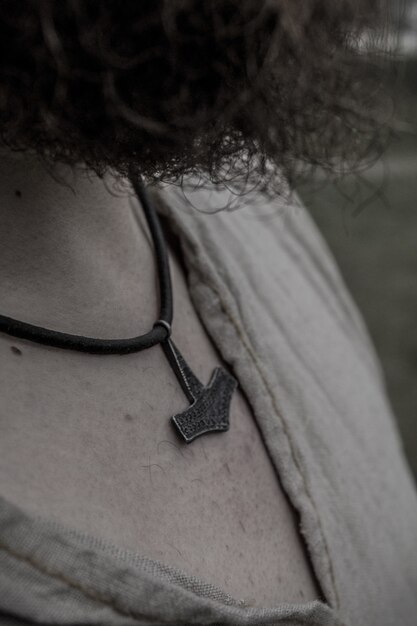 Viking warrior with curly hair wearing a hammer necklace