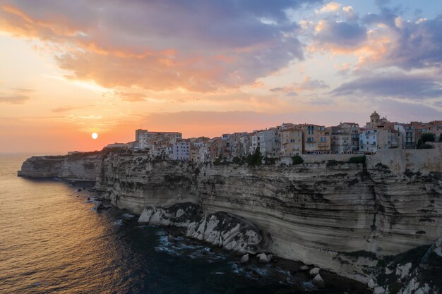 Village on a cliff over the ocean at sunset