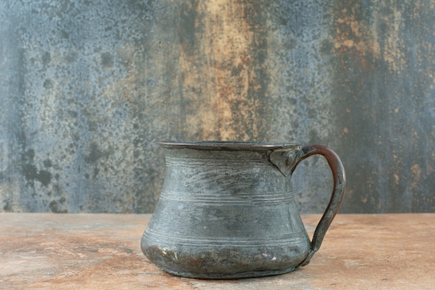 Vintage antique ancient kettle on marble background