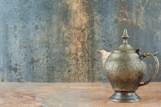 Vintage antique ancient kettle on marble background
