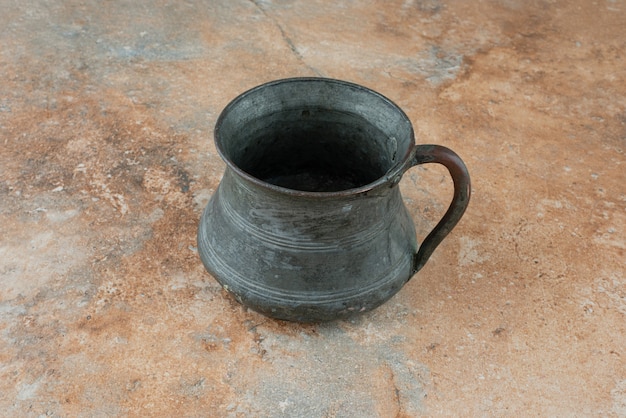 Vintage antique ancient kettle on marble background