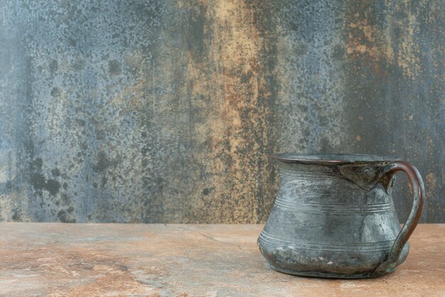 Vintage antique ancient kettle on marble background