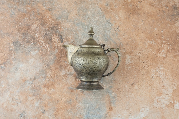 Free photo vintage antique ancient kettle on marble background