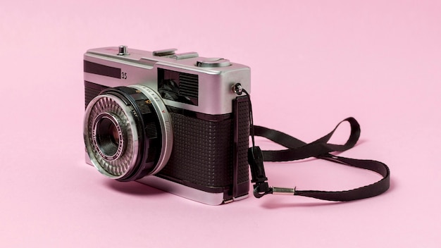 Старинный фотоаппарат на розовом фоне