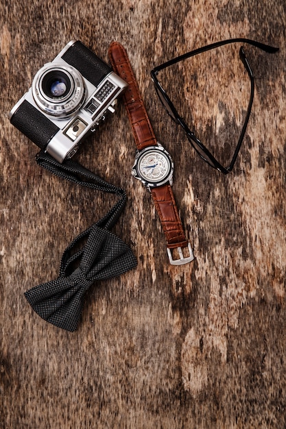 Vintage camera, wrist watch, glasses and bowtie
