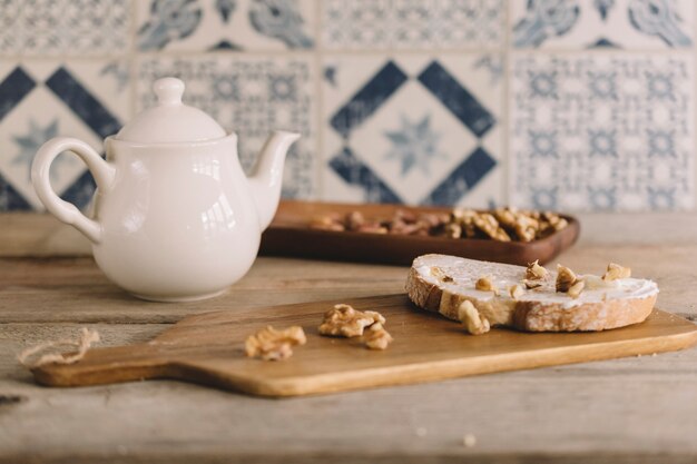 Vintage decoration with nuts on wooden board and tea pot