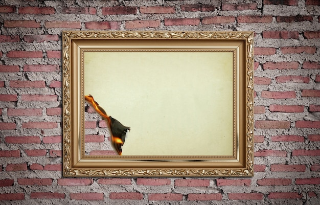 Free photo vintage gold frame with burned on wall  background