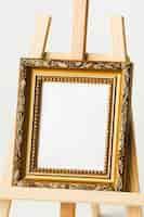 Free photo vintage golden frame on easel