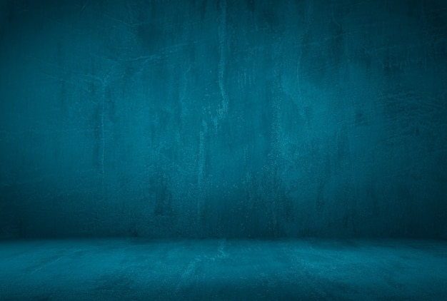 Vintage grunge blue concrete texture studio wall background with vignette.