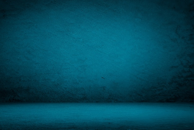 Vintage grunge blue concrete texture studio wall background with vignette.