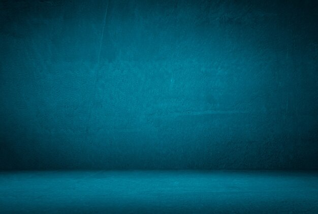 Vintage grunge blue concrete texture studio wall background with vignette.