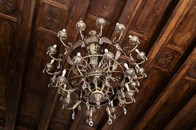 Vintage large chandelier in the palace on the ceiling close-up.