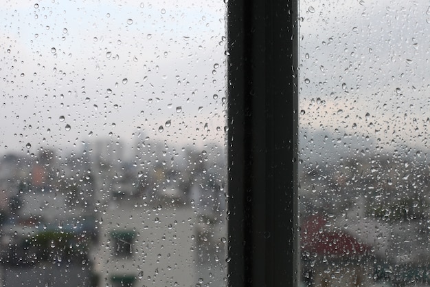 Урожай смотрит Городская сцена просматривается через окно в дождливый день