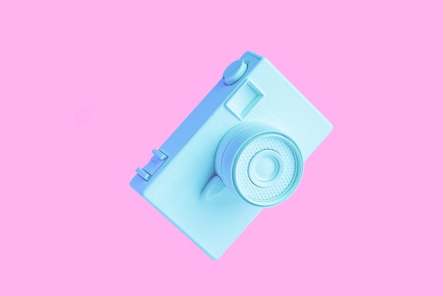 Vintage painted blue camera against pink background