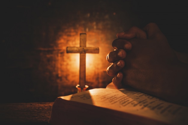 Vintage photo of hand with Bible praying 