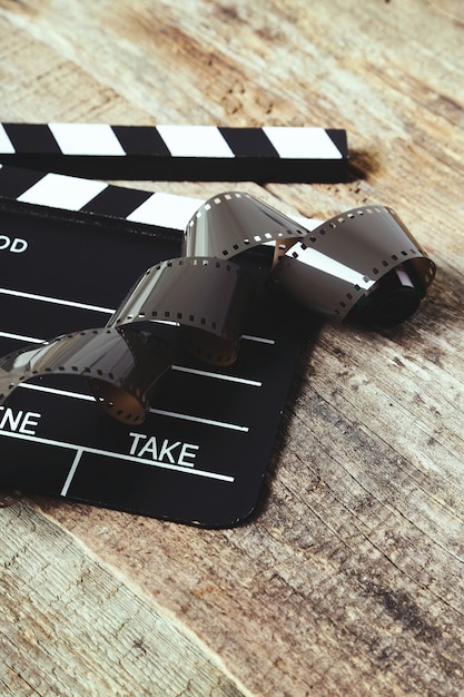 Free photo vintage reel camera tape and clapperboard on wood