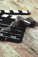 Free photo vintage reel camera tape and clapperboard on wood