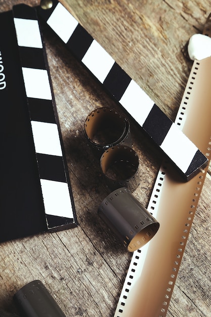 Free photo vintage reel camera tape and clapperboard on wood