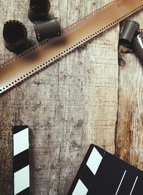 Free photo vintage reel camera tape and clapperboard on wood