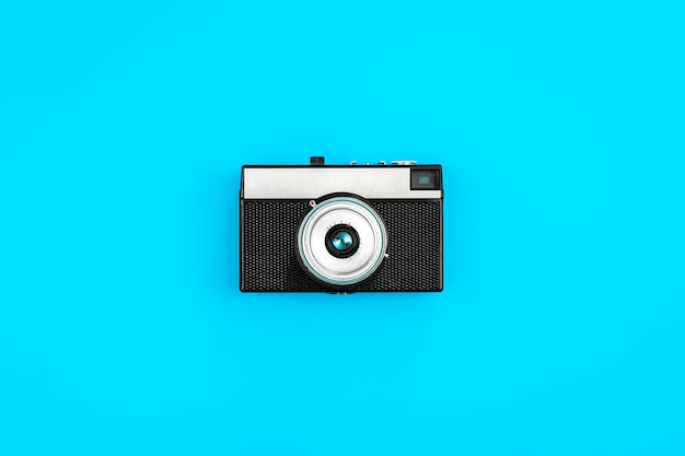 Vintage retro camera on a blue background flat lay