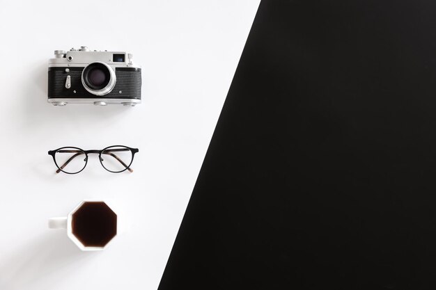 Vintage retro camera glasses and coffee cup on black and white background