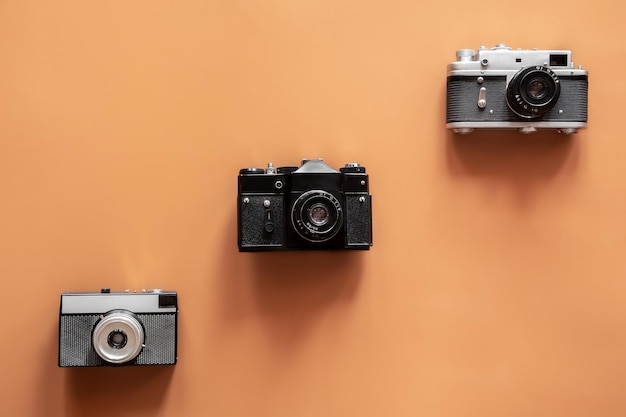 Vintage retro cameras on colored background flat lay