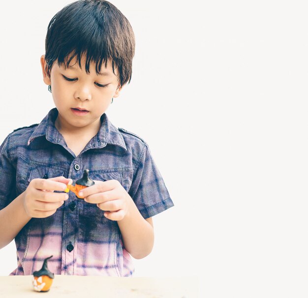 Vintage style of Asian lovely boy is playing Halloween clay happily