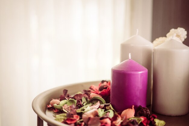 Винтажное фото декоративных свечей и душистых сухих цветочных лепестков в комнате