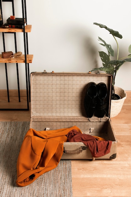 Vintage suitcase with casual clothes on the floor