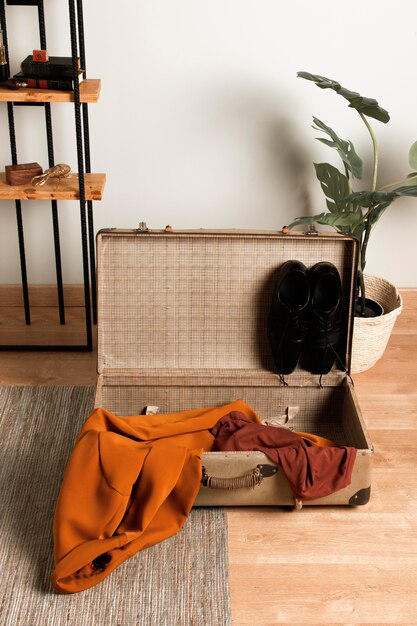 Vintage suitcase with casual clothes on the floor