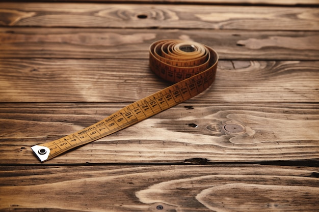 Free photo vintage tailor ruler rolled isolated on rustic wooden table close up