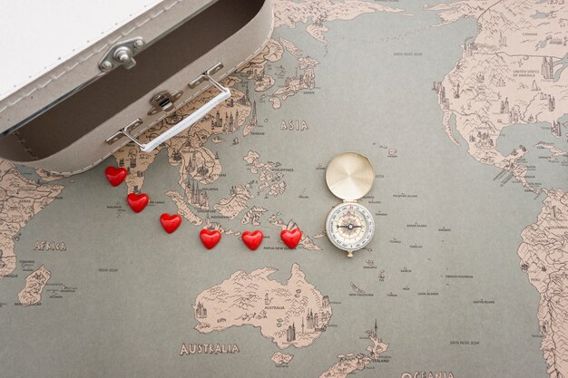 Vintage world map background with suitcase and compass