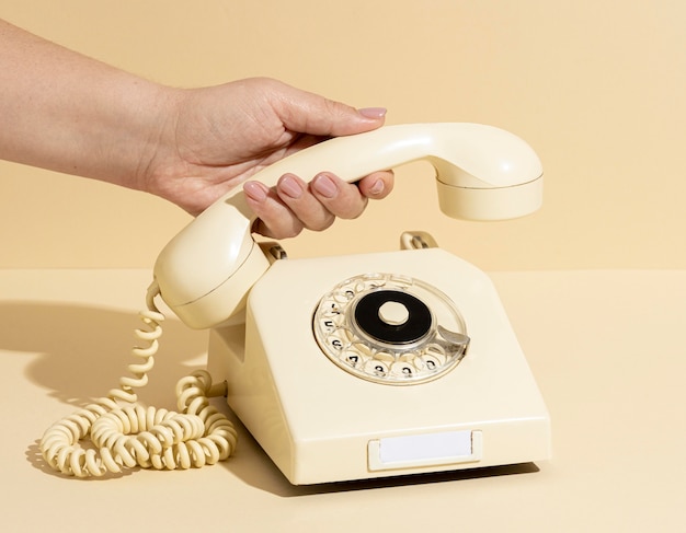 Foto gratuita disposizione del telefono giallo vintage