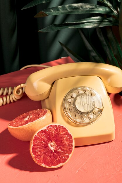 Vintage yellow telephone next to halved grapefruit