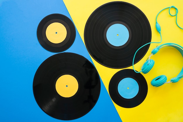 Vinyls and headphones on blue and yellow background