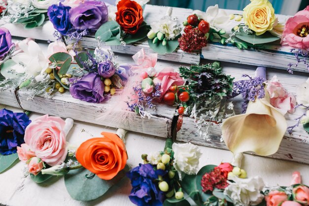 Violet boutonnieres lie among the other on white table