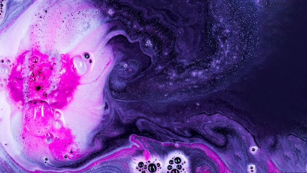 아름다운 분홍색 거품과 물방울이있는 보라색 액체