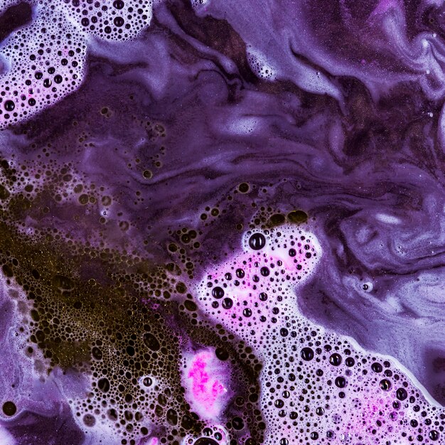 Violet liquid with dark blobs