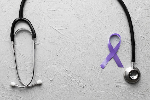 Violet ribbon near black stethoscope on plaster