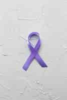 Free photo violet ribbon on plaster background