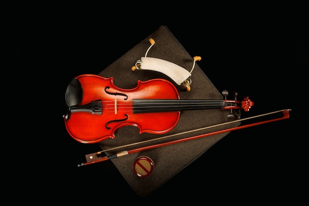 Violin on its special box with its bow on a black